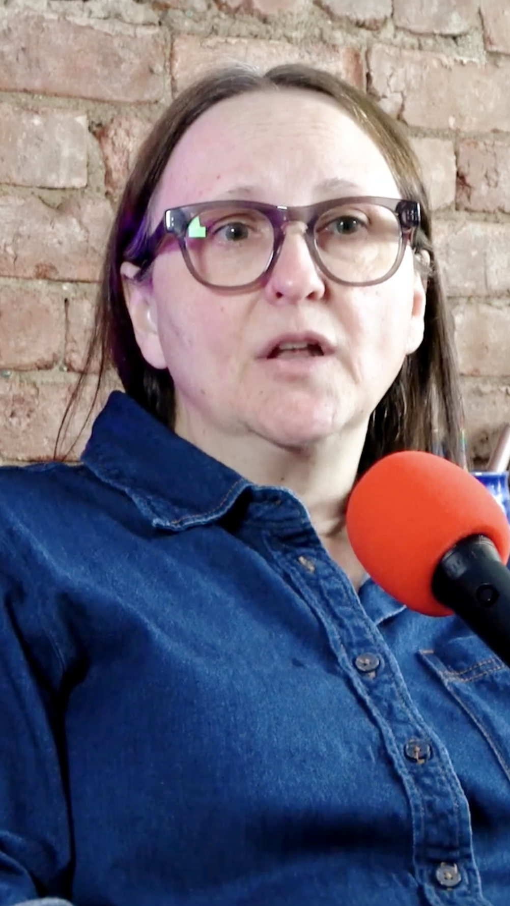Terri Pitts, a Registered Counselling Therapist, sitting in front of a microphone