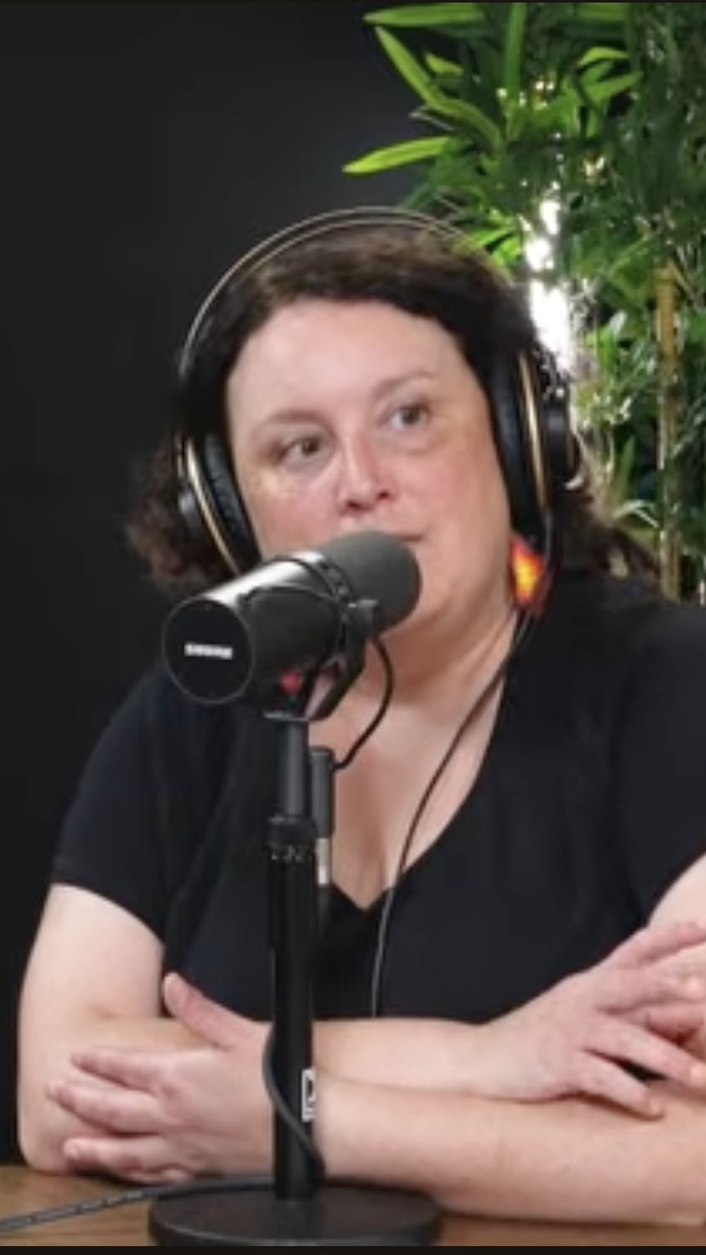 Josie McKinney, lawyer, consultant, and former Crown prosecutor. Photo in studio with headphones and microphone, recording a podcast